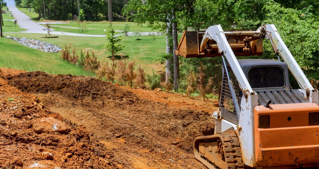 Mini bulldozer working with earth, moving soil doing landscaping works territory improvement